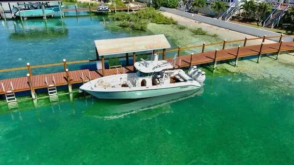 Slide: The Image of Everglades 350 CC 2008 boat docked in clear turquoise water near wooden pier. - 2