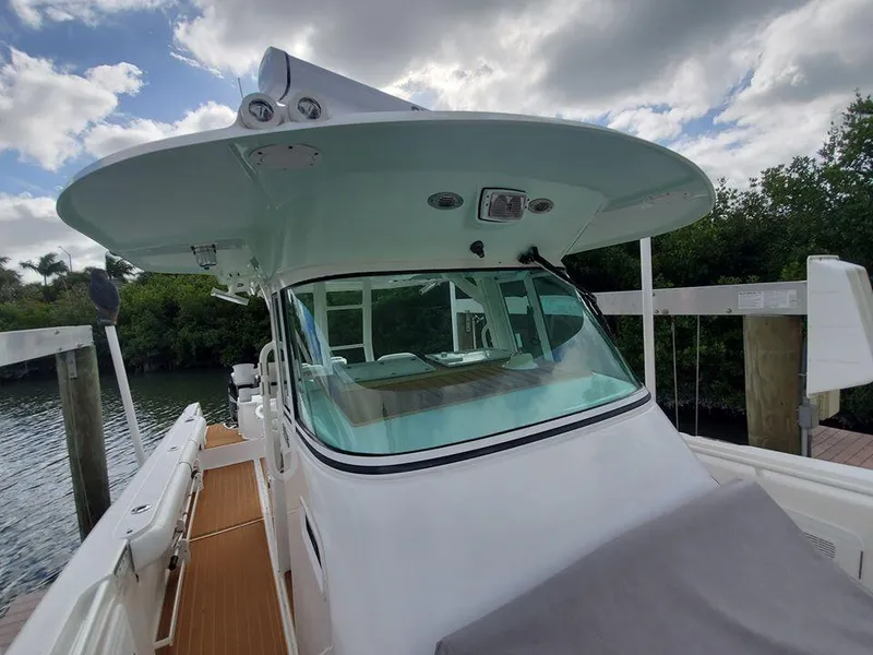Slide: The Image of 2008 Everglades 350 CC boat docked, front view with canopy and windshield. - 30