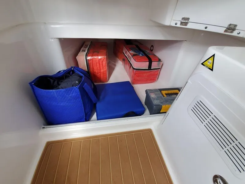 Slide: The Image of Storage compartment of 2008 Everglades 350 CC boat with safety gear and tools. - 32