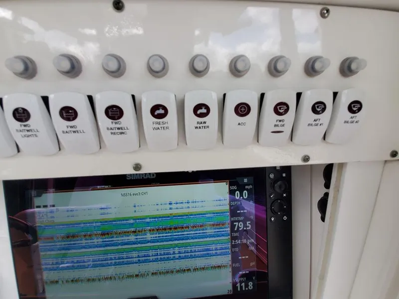 Slide: The Image of Control panel of a 2008 Everglades 350 CC boat with various switches and a Simrad display. - 45