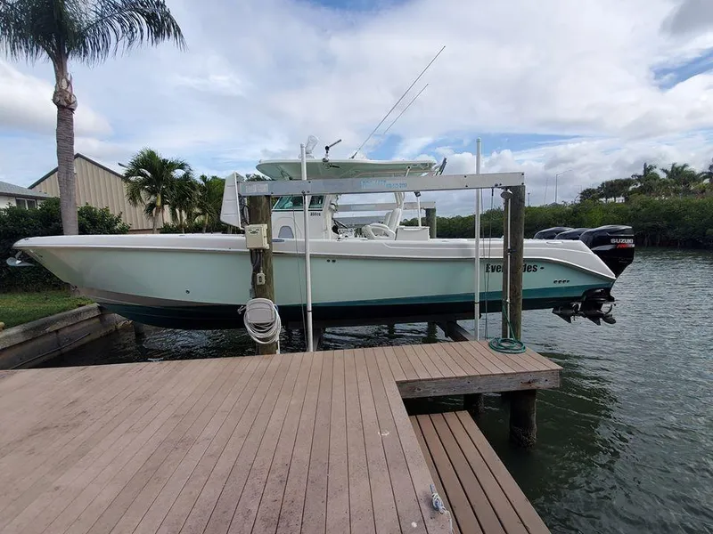 Slide: The Image of 2008 Everglades 350 CC boat docked near a wooden pier with palm trees in the background. - 9