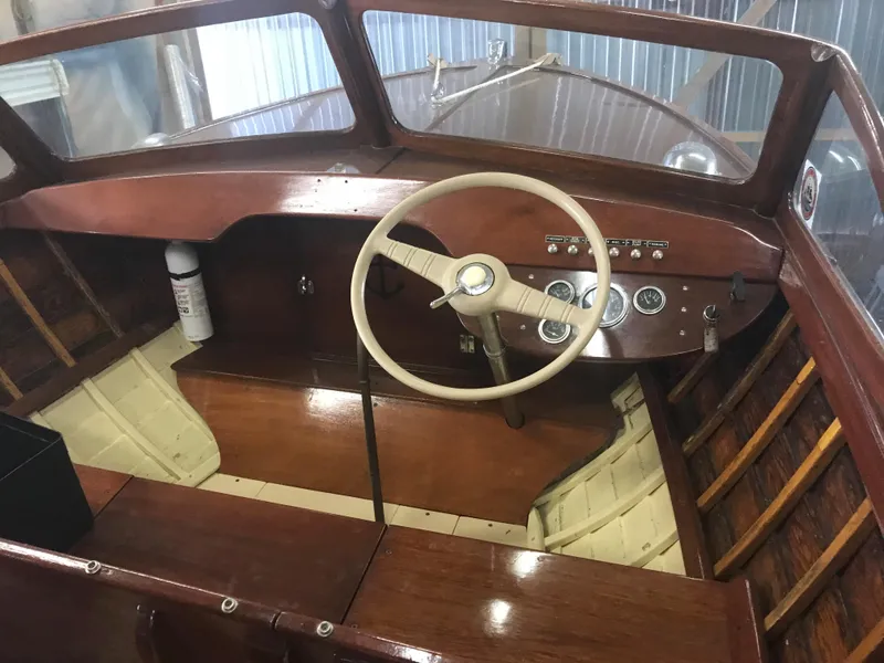 Slide: The Image of 1957 Lyman Islander boat interior with wooden dashboard and steering wheel. - 11