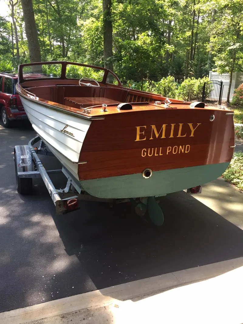 Slide: The Image of 1957 Lyman Islander boat named Emily on a trailer in a wooded area. - 3