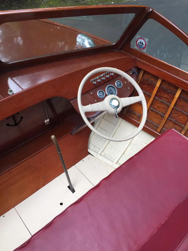 Slide: The Image of 1957 Lyman Islander boat interior with wooden dashboard and white steering wheel. - 5