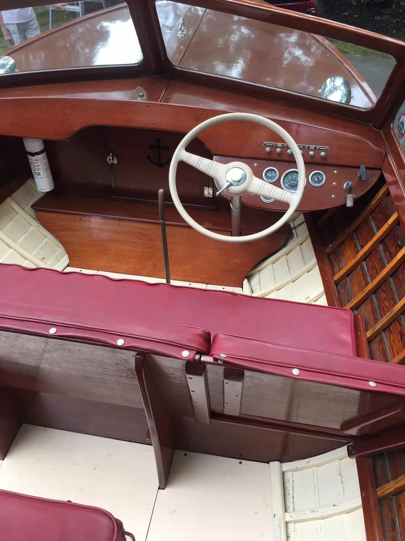 Slide: The Image of 1957 Lyman Islander boat interior with red seats and wooden dashboard. - 6