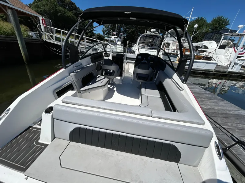 Slide: The Image of 2019 Rinker Q5 OB boat interior with seating, docked at marina. - 11