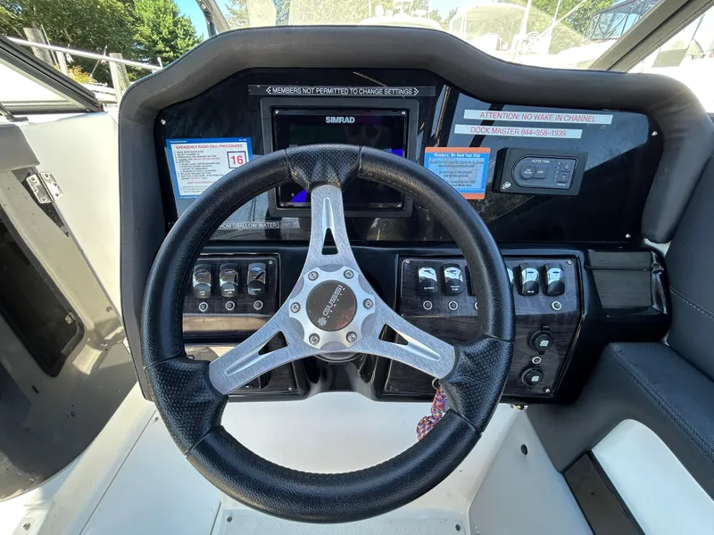 Slide: The Image of Steering wheel and dashboard of 2019 Rinker Q5 OB boat with control panel. - 19