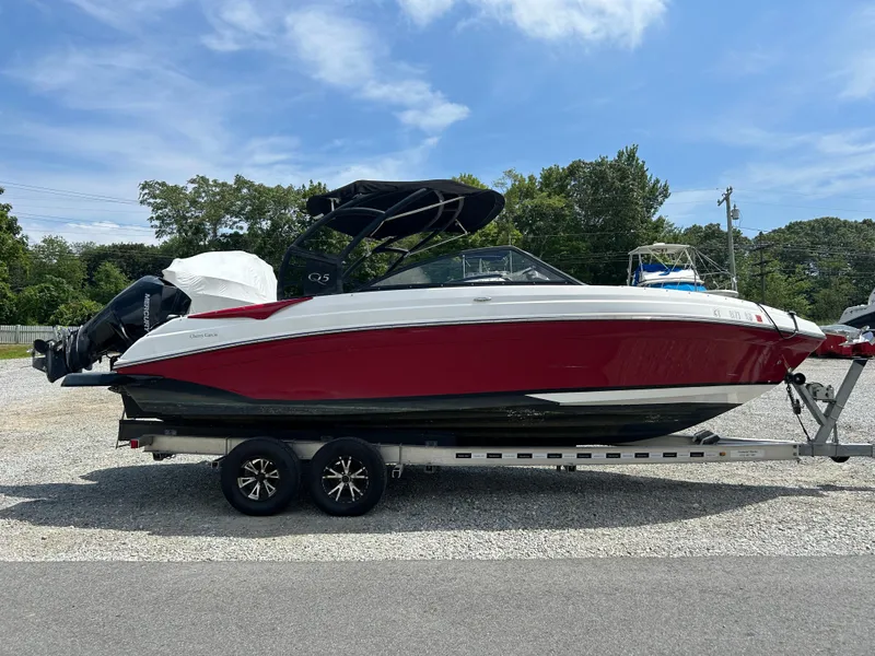 Slide: The Image of 2019 Rinker Q5 OB boat on trailer, red and white design, parked outdoors. - 3