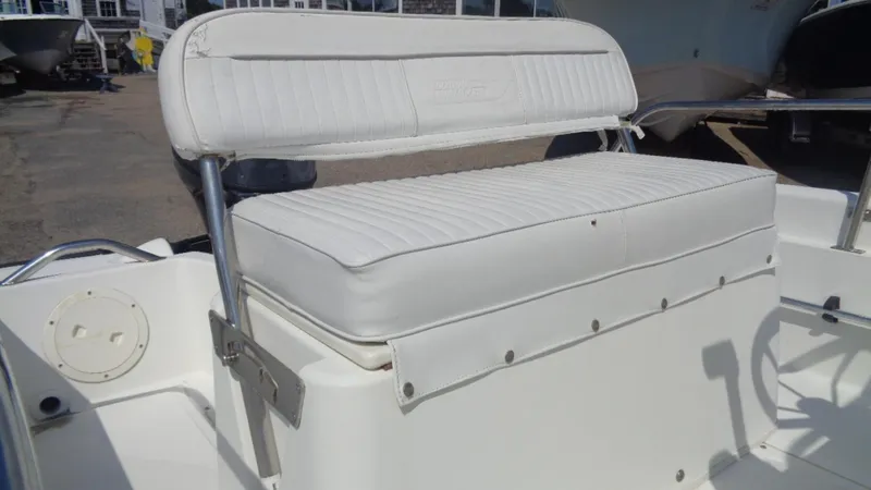 Slide: The Image of 1999 Boston Whaler 140 Dauntless boat seat with white cushioned upholstery. - 10
