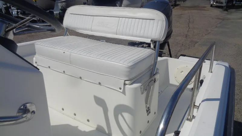 Slide: The Image of 1999 Boston Whaler 140 Dauntless boat interior with white seating and stainless steel railings. - 9