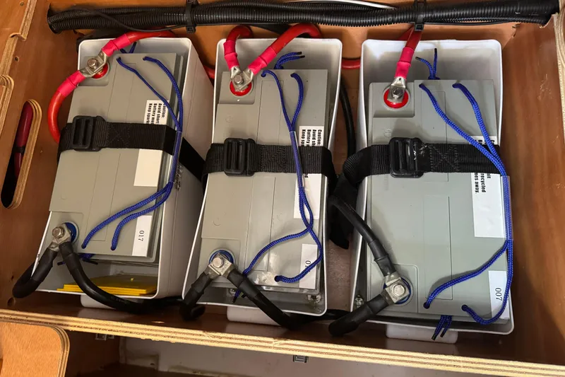 Slide: The Image of Battery compartment of 2018 Jeanneau Sun Odyssey 419 sailboat, featuring three secured batteries. - 16