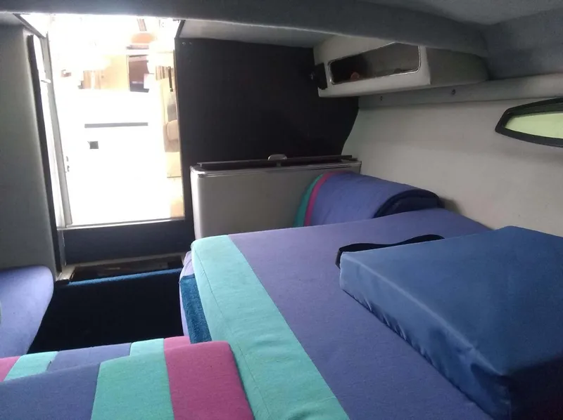Slide: The Image of Interior cabin of 1988 Wellcraft 23 NOVA XL with colorful bedding and compact design. - 5