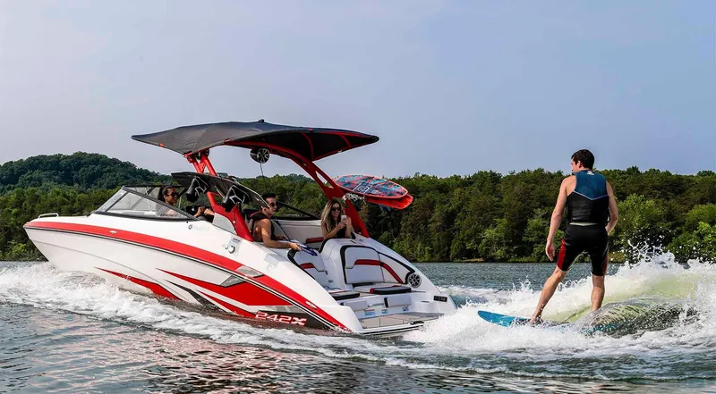 Slide: The Image of 2020 Yamaha Boats 242X towing a wakeboarder on a scenic lake. - 10