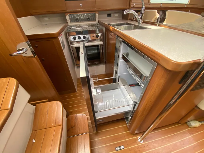 Slide: The Image of Modern Catalina 426 yacht kitchen with open fridge, stove, and wooden cabinetry, 2026 model. - 48