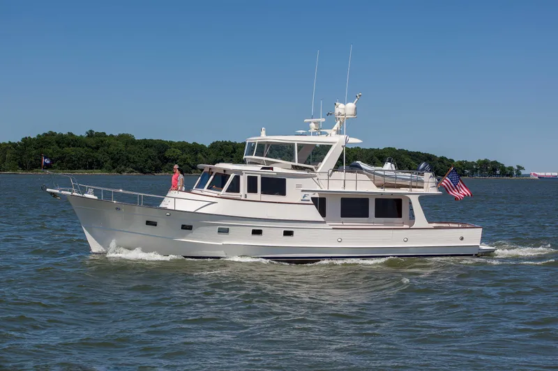 The Image of Fleming 55 yacht cruising on water, 2027 model, with American flag, clear sky. - 0