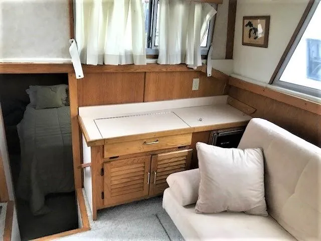 Slide: The Image of Interior of 1986 Silverton 40 Double Cabin with sofa, wooden cabinetry, and window curtains. - 10