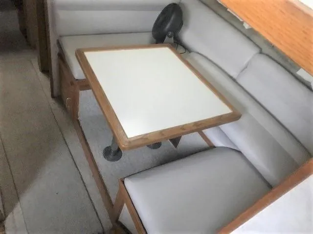 Slide: The Image of 1986 Silverton 40 Double Cabin interior dining area with table and cushioned seating. - 11