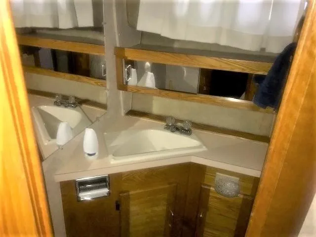 Slide: The Image of 1986 Silverton 40 Double Cabin bathroom with sink, mirror, and wooden cabinetry. - 15