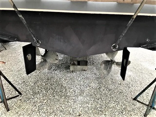 Slide: The Image of 1986 Silverton 40 Double Cabin boat propellers and rudders on gravel. - 5