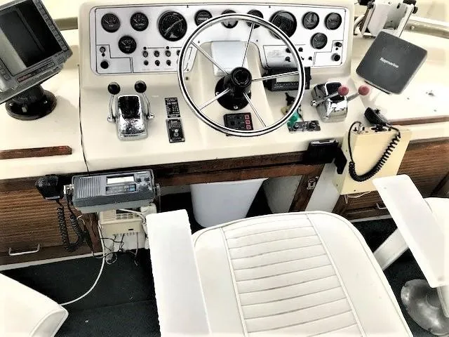Slide: The Image of 1986 Silverton 40 Double Cabin boat helm with steering wheel, gauges, and navigation equipment. - 6