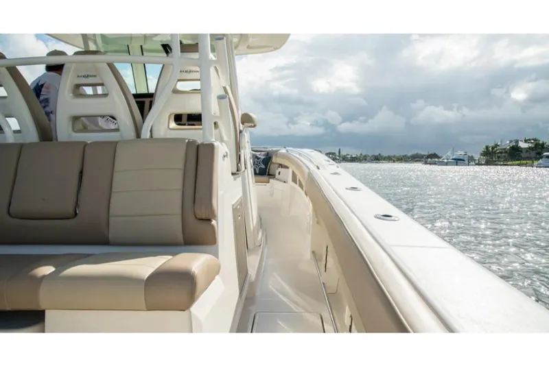 Slide: The Image of 2023 Sailfish 360 CC boat interior with beige seating, docked by the water. - 19