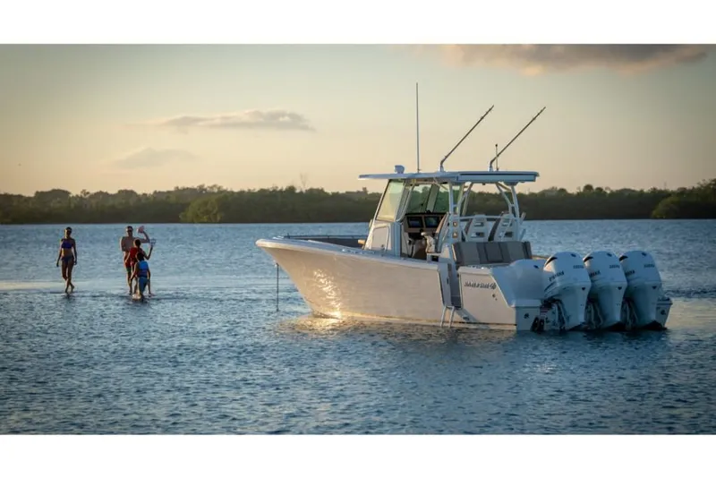 Slide: The Image of 2023 Sailfish 360 CC boat on calm water with people in the background. - 24