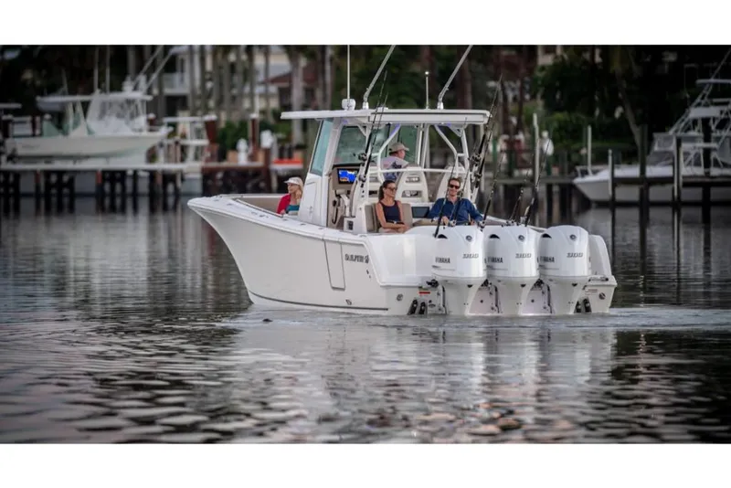 Slide: The Image of 2023 Sailfish 360 CC boat cruising on calm waters with multiple outboard engines. - 25