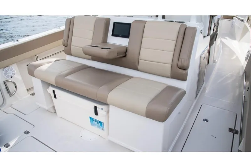 Slide: The Image of 2023 Sailfish 360 CC boat interior with beige and brown cushioned seating. - 31
