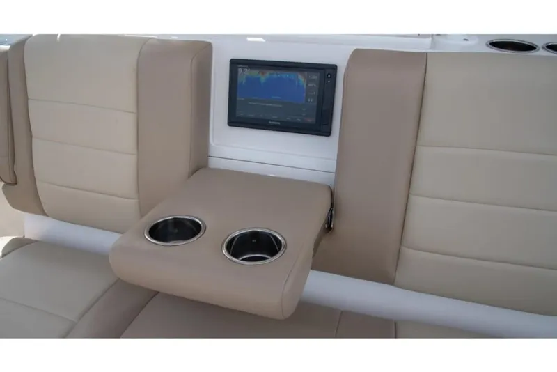 Slide: The Image of 2023 Sailfish 360 CC boat interior with beige seating and built-in cup holders. - 32