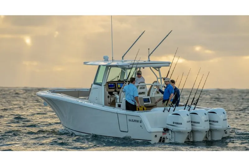 Slide: The Image of 2023 Sailfish 360 CC boat with triple Yamaha engines on the water at sunset. - 4