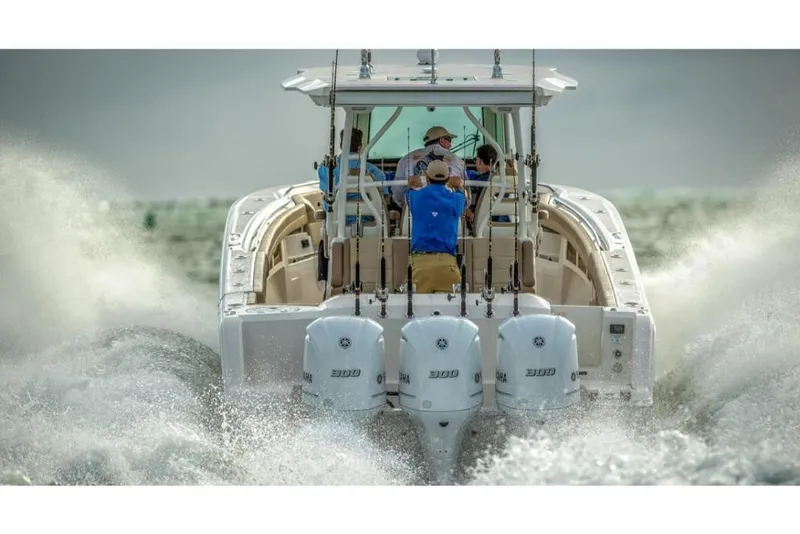 Slide: The Image of 2023 Sailfish 360 CC boat speeding on water with three outboard engines. - 6