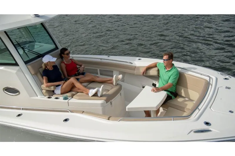 Slide: The Image of 2023 Sailfish 360 CC boat with people relaxing in the seating area. - 8