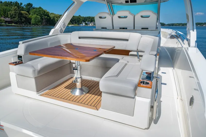 Slide: The Image of 2025 Tiara Sport 38 LS luxury boat with spacious seating and wooden table. - 12