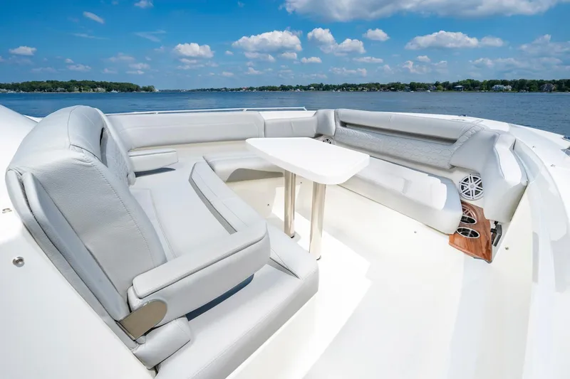 Slide: The Image of 2025 Tiara Sport 38 LS boat interior with seating and table on a sunny day. - 19
