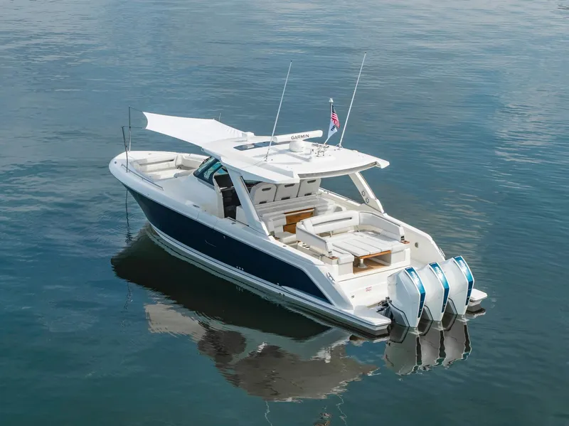 Slide: The Image of 2025 Tiara Sport 38 LS luxury boat with triple outboard engines on calm water. - 2