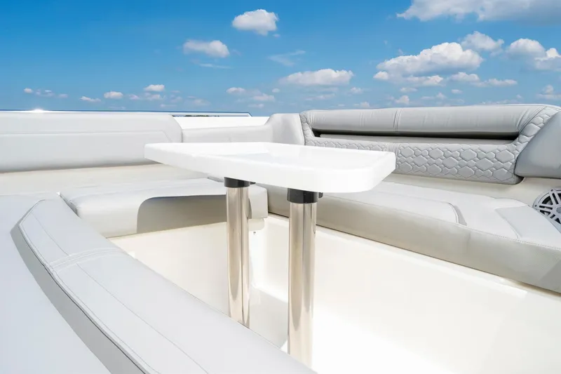 Slide: The Image of 2025 Tiara Sport 38 LS boat interior with white seating and table under blue sky. - 21