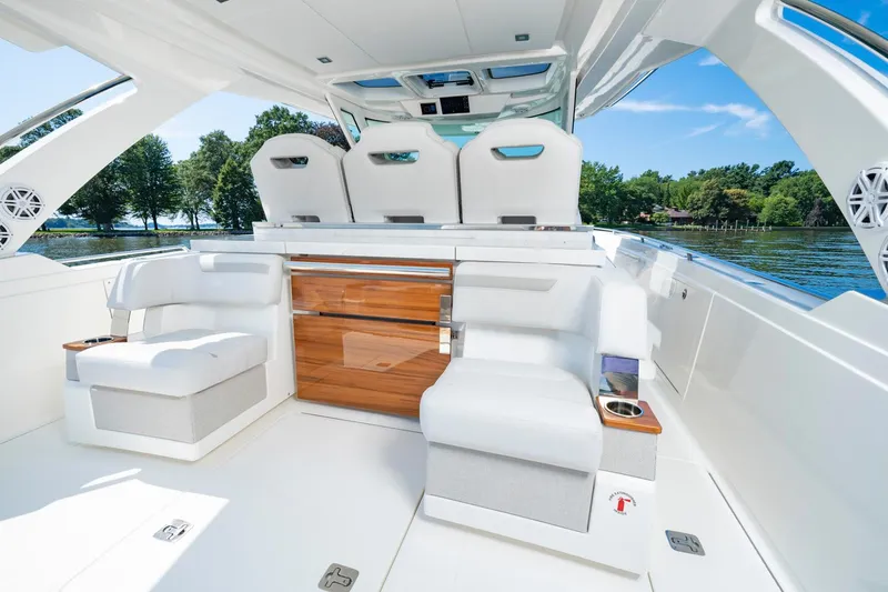Slide: The Image of 2025 Tiara Sport 38 LS luxury boat interior with white seating and wooden accents. - 23
