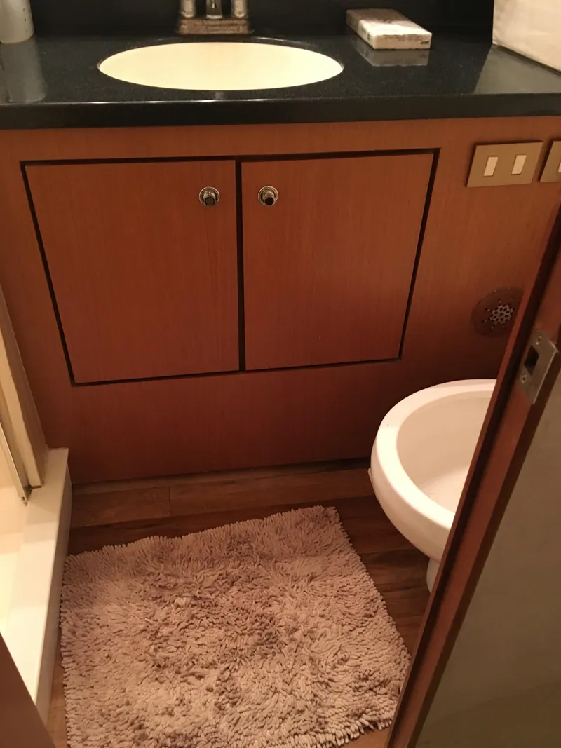 Slide: The Image of 2001 Ocean Yachts 56 Super Sport bathroom with sink, toilet, and wooden cabinets. - 32