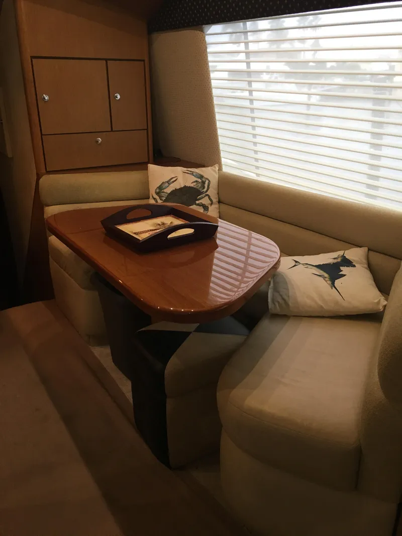 Slide: The Image of 2001 Ocean Yachts 56 Super Sport interior dining area with cushioned seating and decorative pillows. - 35