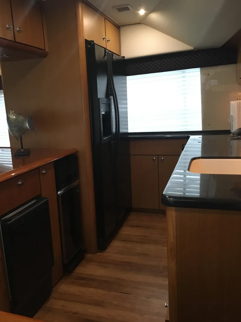 Slide: The Image of Modern kitchen interior of a 2001 Ocean Yachts 56 Super Sport with wood cabinetry and black appliances. - 36