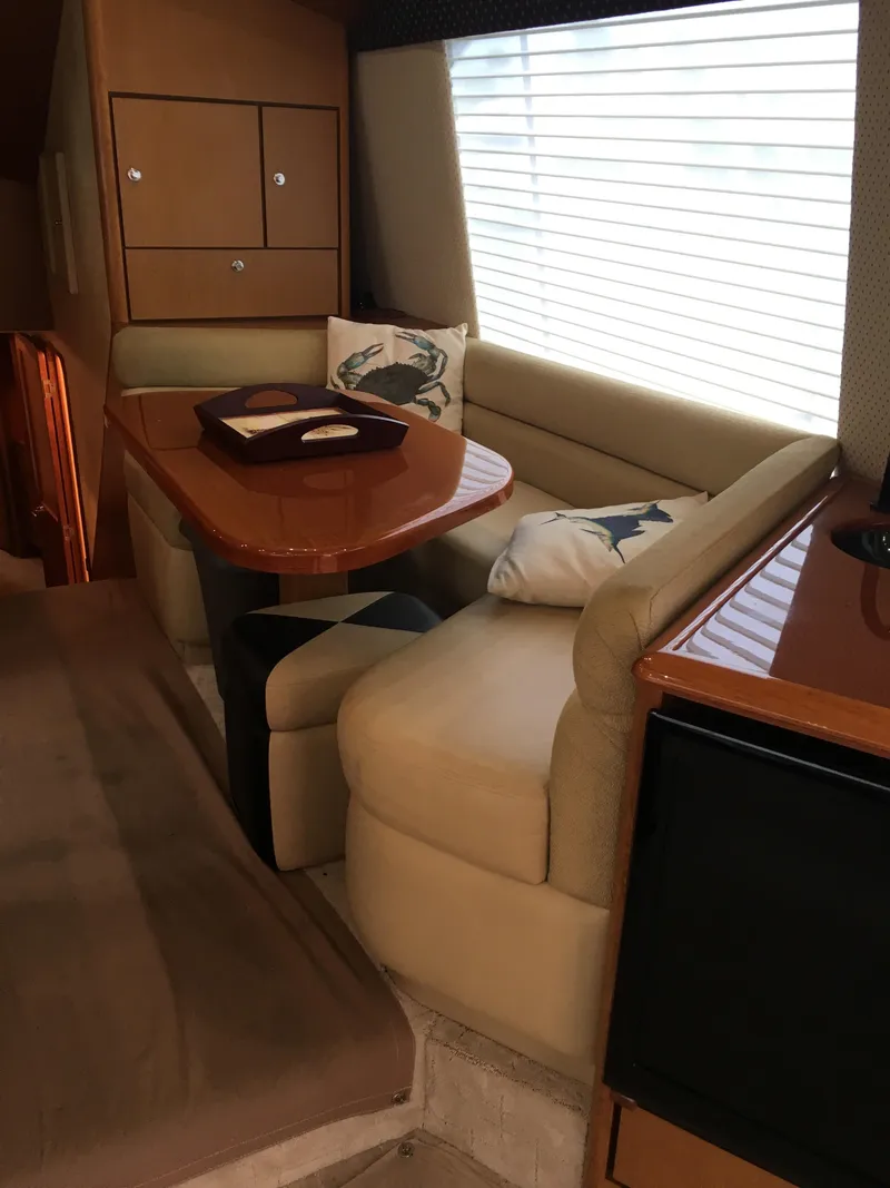 Slide: The Image of Interior dining area of a 2001 Ocean Yachts 56 Super Sport with beige seating and wooden table. - 20