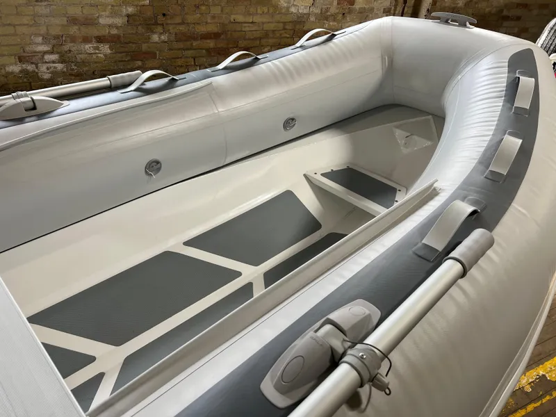 Slide: The Image of 2023 Gala A300 Ultra Lite inflatable boat interior, gray and white, close-up view. - 2
