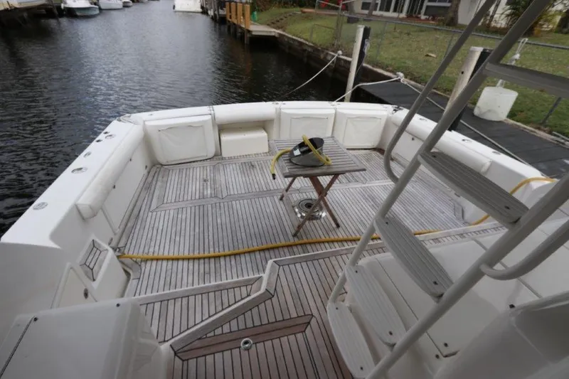 Slide: The Image of 2004 Riviera 58 Enclosed Flybridge yacht deck with ladder and table. - 25