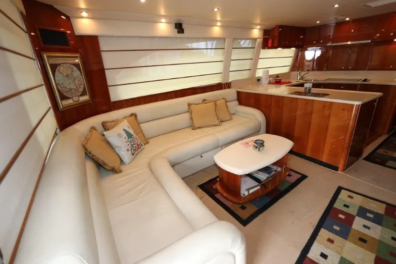 Slide: The Image of Luxurious interior of 2004 Riviera 58 Enclosed Flybridge yacht with white leather sofa and wooden cabinetry. - 5