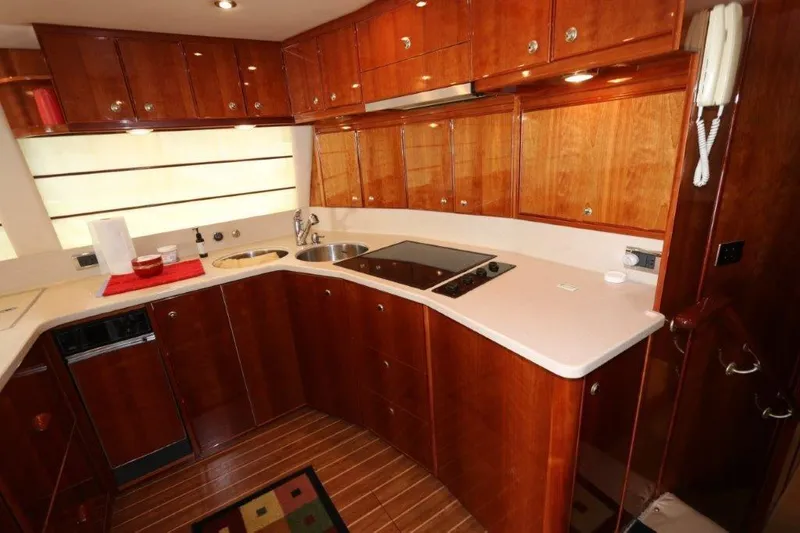 Slide: The Image of 2004 Riviera 58 Enclosed Flybridge yacht kitchen with wooden cabinets and modern appliances. - 9