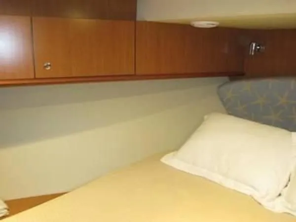 Slide: The Image of 2008 Luhrs 35C cabin with bed and wooden storage cabinets. - 24