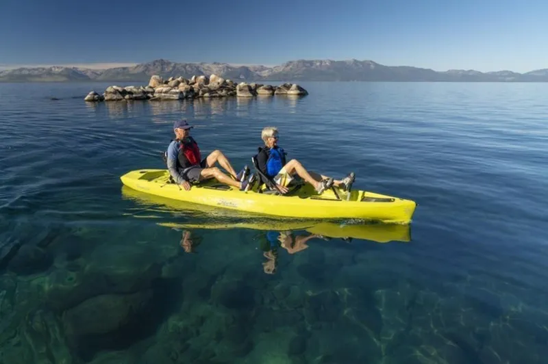 The Image of Two people kayaking on a 2023 Hobie Compass Duo in clear blue water. - 0