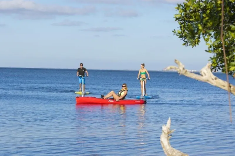 Slide: The Image of People enjoying water activities with a 2023 Hobie Revolution 11 kayak. - 2