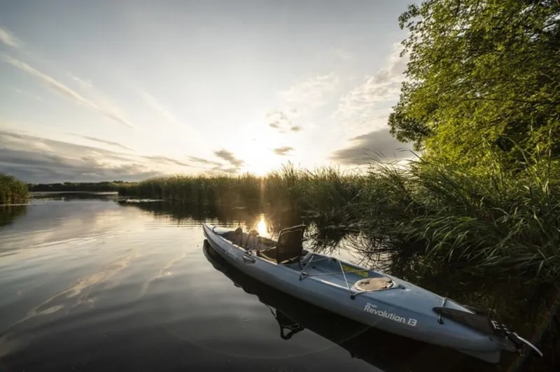 Slide: The Image of Hobie Revolution 13 kayak on a serene lake at sunset, 2023 model. - 11
