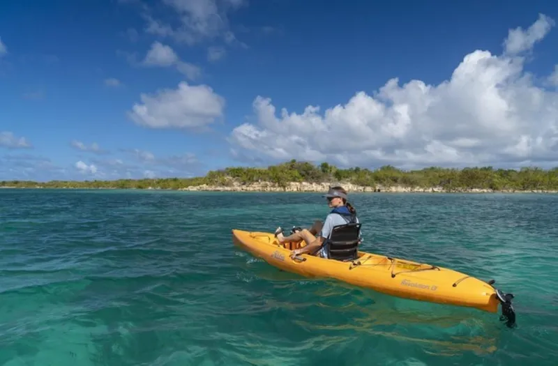 Slide: The Image of Person kayaking on a 2023 Hobie Revolution 13 in clear blue waters. - 12